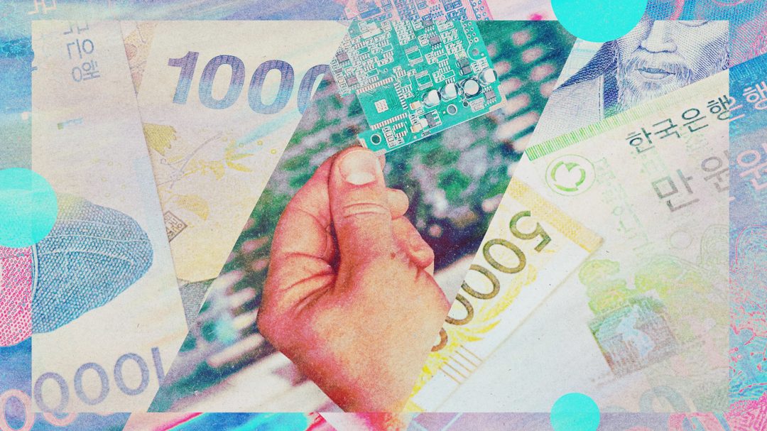 a hand holding a circuit board divides South Korean won to the left and right